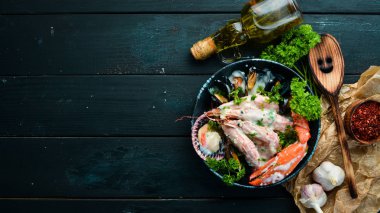 Siyah taş tabaktabaktabaktabaktabaktabaktabaktabaktabakta kremalı soslu haşlanmış deniz ürünleri. Deniz ürünleri, karides, kabuklu deniz ürünleri, ıstakoz. Üst te. Ücretsiz kopyalama alanı.