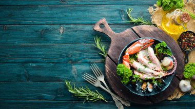 Siyah taş tabaktabaktabaktabaktabaktabaktabaktabaktabakta kremalı soslu haşlanmış deniz ürünleri. Deniz ürünleri, karides, kabuklu deniz ürünleri, ıstakoz. Üst te. Ücretsiz kopyalama alanı.