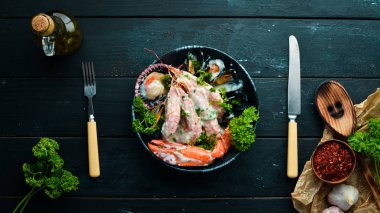 Siyah taş tabaktabaktabaktabaktabaktabaktabaktabaktabakta kremalı soslu haşlanmış deniz ürünleri. Deniz ürünleri, karides, kabuklu deniz ürünleri, ıstakoz. Üst te. Ücretsiz kopyalama alanı.