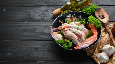 Siyah taş tabaktabaktabaktabaktabaktabaktabaktabaktabakta kremalı soslu haşlanmış deniz ürünleri. Deniz ürünleri, karides, kabuklu deniz ürünleri, ıstakoz. Üst te. Ücretsiz kopyalama alanı.