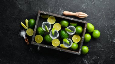 Tekila tuzu ve kireç. Alkol. Siyah taş bir arka plan üzerinde. Üst te. Metniniz için boş alan.