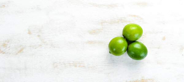 Зеленые липы на белом деревянном фоне. Фрукты Вид сверху. Свободное место для текста
.