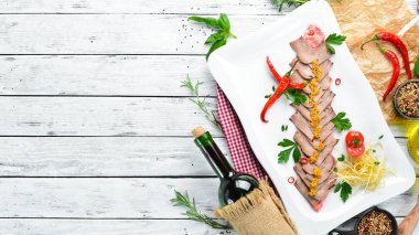 Bir tabakta sebze ve baharat ile haşlanmış dana dili. Restoran yemekleri. Üst te. Metniniz için boş alan.