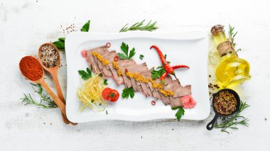 Bir tabakta sebze ve baharat ile haşlanmış dana dili. Restoran yemekleri. Üst te. Metniniz için boş alan.