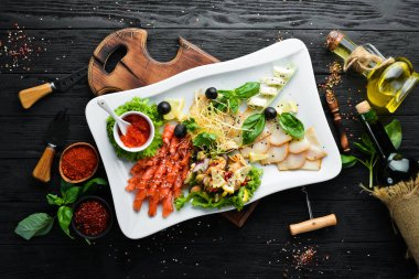 Bir tabakta çeşitli deniz ürünleri. Somon, havyar, midye, ahtapot. Restoran yemekleri. Üst te. Metniniz için boş alan.