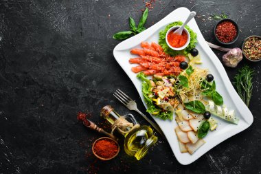 Bir tabakta çeşitli deniz ürünleri. Somon, havyar, midye, ahtapot. Restoran yemekleri. Üst te. Metniniz için boş alan.