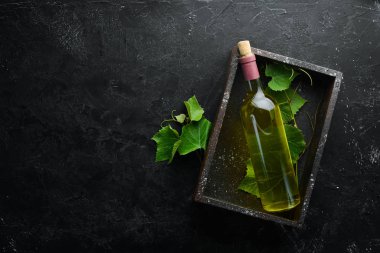 Siyah taş masada bir şişe beyaz şarap ve taze üzüm. Üst te. Metniniz için boş alan.