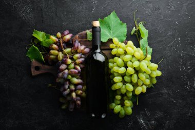 Kırmızı şarap ve taze üzüm siyah taş bir masada. Üst te. Metniniz için boş alan.
