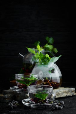 Kuş üzümü ve nane çayı. Sıcak kış içecekleri. Siyah bir arka plan üzerinde. Üstte görüntü.
