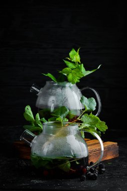 Kuş üzümü ve nane çayı. Sıcak kış içecekleri. Siyah bir arka plan üzerinde. Üstte görüntü.