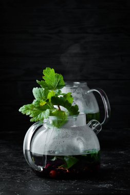 Kuş üzümü ve nane çayı. Sıcak kış içecekleri. Siyah bir arka plan üzerinde. Üstte görüntü.