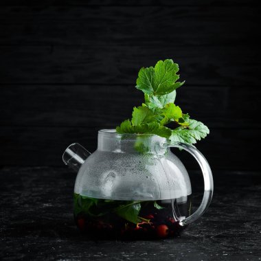 Kuş üzümü ve nane çayı. Sıcak kış içecekleri. Siyah bir arka plan üzerinde. Üstte görüntü.