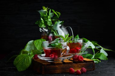 Ahududu ve nane çayı. Sıcak kış içecekleri. Siyah bir arka plan üzerinde. Üstte görüntü.