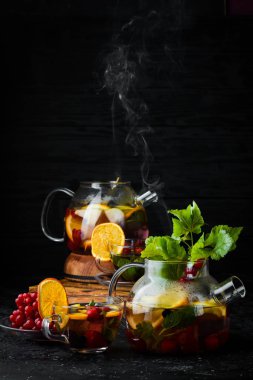 Orman meyvesi ve meyve çayı. Sıcak kış içecekleri. Siyah bir arka plan üzerinde. Üstte görüntü.