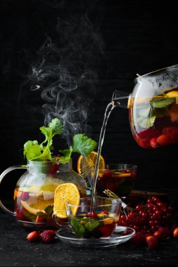 Orman meyvesi ve meyve çayı. Sıcak kış içecekleri. Siyah bir arka plan üzerinde. Üstte görüntü.