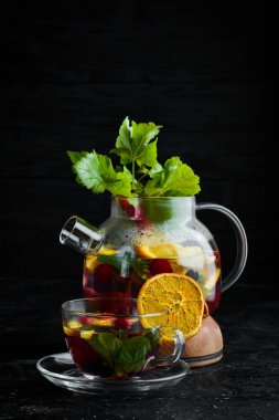 Orman meyvesi ve meyve çayı. Sıcak kış içecekleri. Siyah bir arka plan üzerinde. Üstte görüntü.