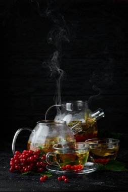 Viburnum ve orman otlarından çay. Sıcak kış içecekleri. Siyah bir arka plan üzerinde. Üstte görüntü.