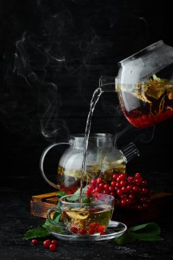 Viburnum ve orman otlarından çay. Sıcak kış içecekleri. Siyah bir arka plan üzerinde. Üstte görüntü.