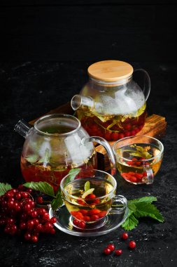 Viburnum ve orman otlarından çay. Sıcak kış içecekleri. Siyah bir arka plan üzerinde. Üstte görüntü.