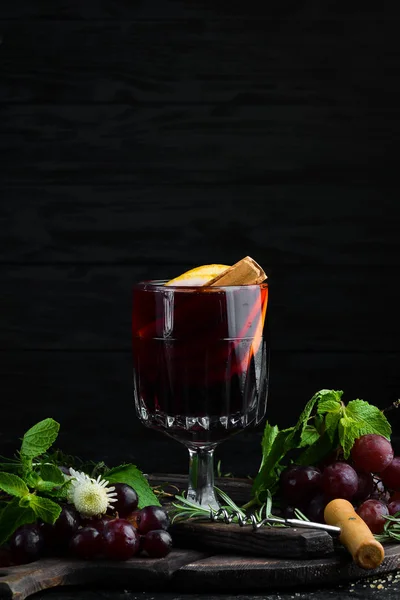 Mulled wine. Hot wine with orange, apple and cinnamon. In the glass. Top view. On a black background.