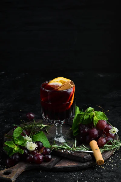 Mulled wine. Hot wine with orange, apple and cinnamon. In the glass. Top view. On a black background.