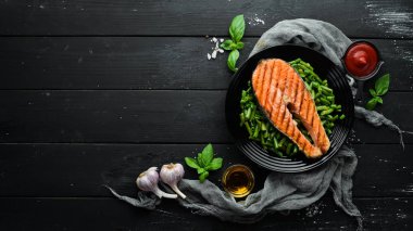 Siyah tabakta yeşil fasulyeli fırında somon bifteği. Üst Manzara. Boş kopyalama alanı.