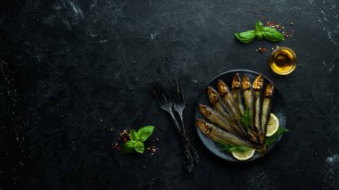 Siyah tabakta limonlu füme capelin balığı. Üst Manzara. Boş kopyalama alanı.