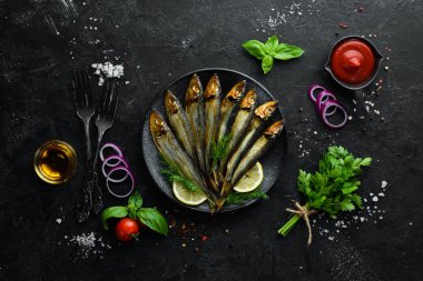 Siyah tabakta limonlu füme capelin balığı. Üst Manzara. Boş kopyalama alanı.