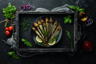 Siyah tabakta limonlu füme capelin balığı. Üst Manzara. Boş kopyalama alanı.
