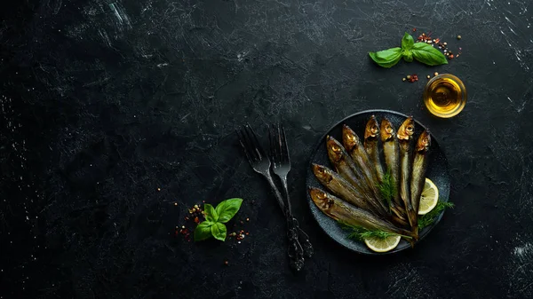 Siyah tabakta limonlu füme capelin balığı. Üst Manzara. Boş kopyalama alanı.