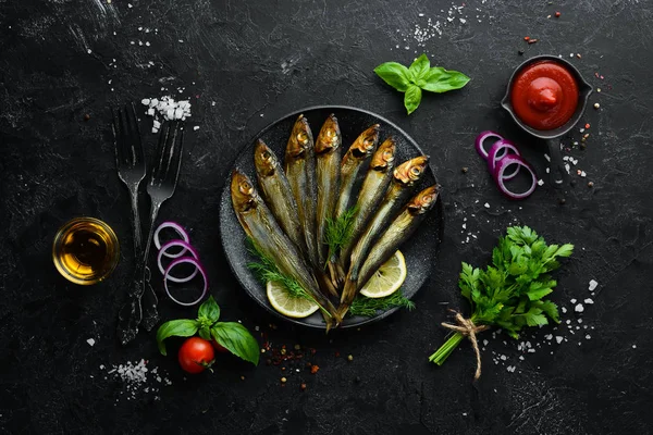 Siyah tabakta limonlu füme capelin balığı. Üst Manzara. Boş kopyalama alanı.
