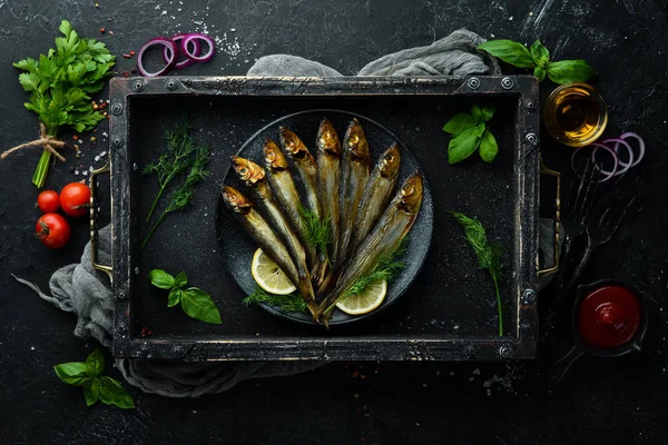 Siyah tabakta limonlu füme capelin balığı. Üst Manzara. Boş kopyalama alanı.
