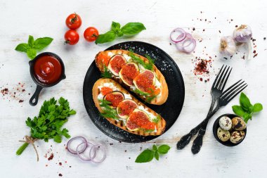 Havyarlı sandviç, beyaz peynir ve siyah tabakta incir. Üst Manzara. Boş kopyalama alanı.