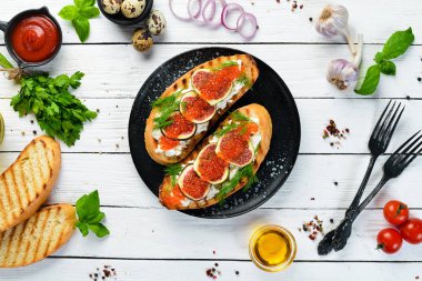 Havyarlı sandviç, beyaz peynir ve siyah tabakta incir. Üst Manzara. Boş kopyalama alanı.