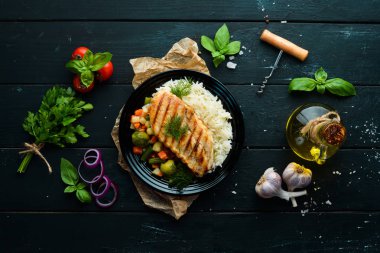 Siyah tabakta pilav ve sebzeli fırında tavuk filetosu. Üst Manzara. Boş kopyalama alanı.