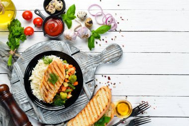 Siyah tabakta pilav ve sebzeli fırında tavuk filetosu. Üst Manzara. Boş kopyalama alanı.