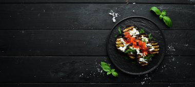 Siyah tabakta fırında patlıcan, havyar ve peynir. Düz yatıyordu. Üst Manzara. Boş kopyalama alanı.