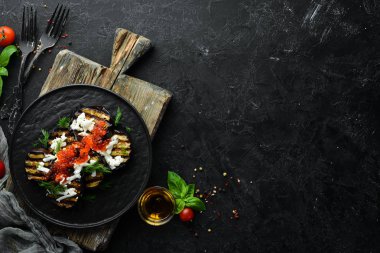 Siyah tabakta fırında patlıcan, havyar ve peynir. Düz yatıyordu. Üst Manzara. Boş kopyalama alanı.