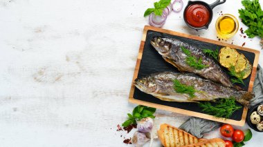 Taş bir tahtanın üzerinde pişmiş alabalık. Düz yatıyordu. Üst Manzara. Boş kopyalama alanı.