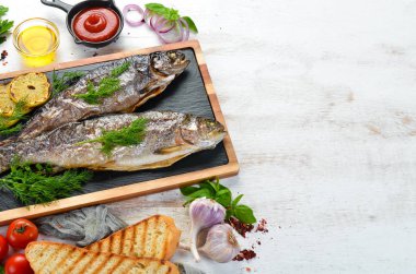 Taş bir tahtanın üzerinde pişmiş alabalık. Düz yatıyordu. Üst Manzara. Boş kopyalama alanı.