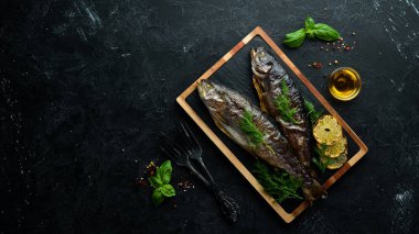 Taş bir tahtanın üzerinde pişmiş alabalık. Düz yatıyordu. Üst Manzara. Boş kopyalama alanı.