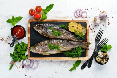 Taş bir tahtanın üzerinde pişmiş alabalık. Düz yatıyordu. Üst Manzara. Boş kopyalama alanı.