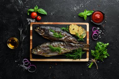 Taş bir tahtanın üzerinde pişmiş alabalık. Düz yatıyordu. Üst Manzara. Boş kopyalama alanı.