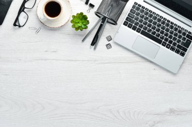 Boş defterli beyaz ofis masası, bilgisayar klavyesi ve ofis malzemeleri. Kopyalama alanı olan üst görünüm, düz yatay.