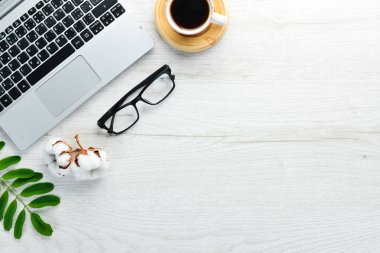 Boş defterli beyaz ofis masası, bilgisayar klavyesi ve ofis malzemeleri. Kopyalama alanı olan üst görünüm, düz yatay.