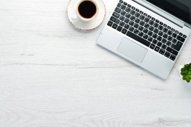 Boş defterli beyaz ofis masası, bilgisayar klavyesi ve ofis malzemeleri. Kopyalama alanı olan üst görünüm, düz yatay.