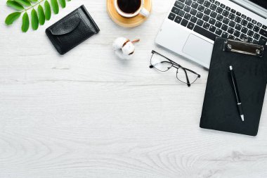 Boş defterli beyaz ofis masası, bilgisayar klavyesi ve ofis malzemeleri. Kopyalama alanı olan üst görünüm, düz yatay.