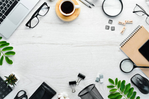 White office desk with blank notebook, computer keyboard and office supplies. Top view with copy space, flat lay.