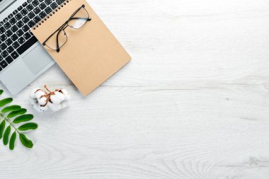 Not defteri ve ofis malzemeleriyle dolu beyaz ofis masası. Kopyalama alanı olan üst görünüm, düz yatay.