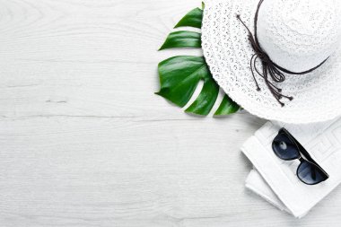 Beyaz ahşap arka planda güneş gözlüğü ve şapka. Üst Manzara. Boş kopyalama alanı.